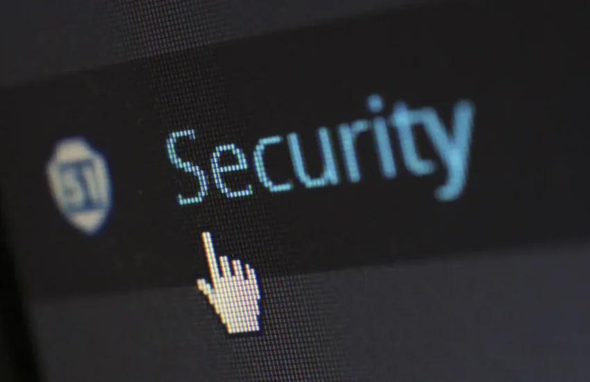 Zbliżenie ekranu z napisem Security i kursorem w kształcie dłoni, widoczna siatka pikseli