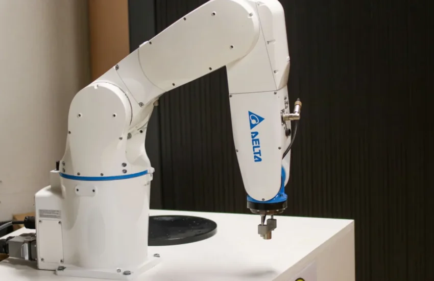 Biały przemysłowy robot sześcioosiowy na stanowisku laboratoryjnym